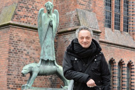 Feridun Zaimoglu vor Barlachs Geistkämpfer an der Kieler St. Nikolai-Kirche